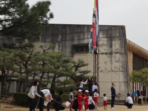 知事とこどもたちがこいのぼりを掲揚している様子