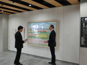 齋正機氏の絵の説明を受ける知事