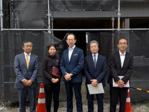 建設中の移住者（世帯用）住宅の前での記念撮影