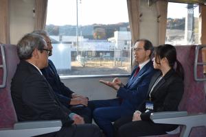 電車で関係者らと話す知事