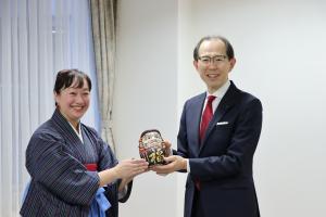 千葉清藍氏ほか関係者の皆さまからの贈り物である達磨を持つ知事